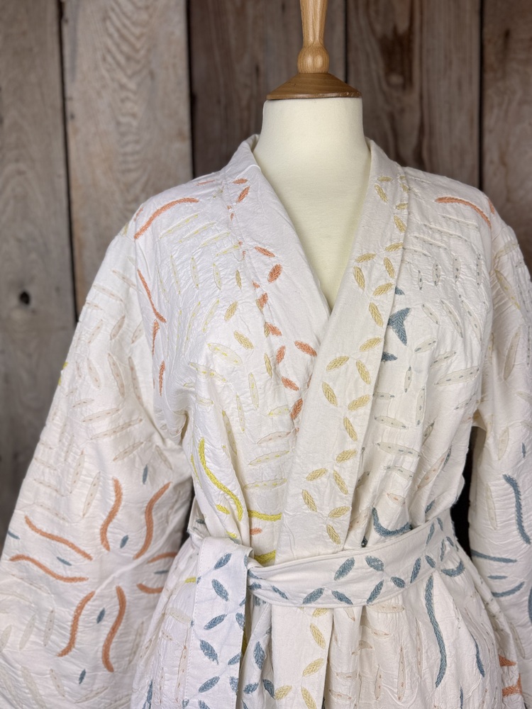 A luxury white dressing gown made using the traditional Indian technique of Cutwork. Additional hand embroidery in pastel shades.