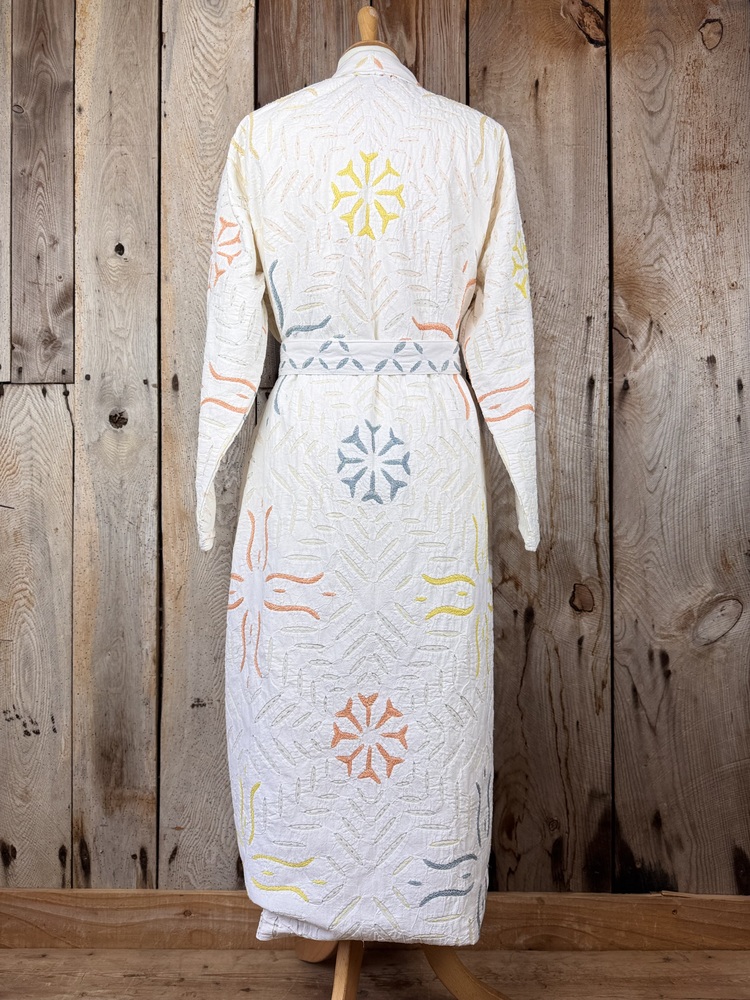 A luxury white dressing gown made using the traditional Indian technique of Cutwork. Additional hand embroidery in pastel shades.