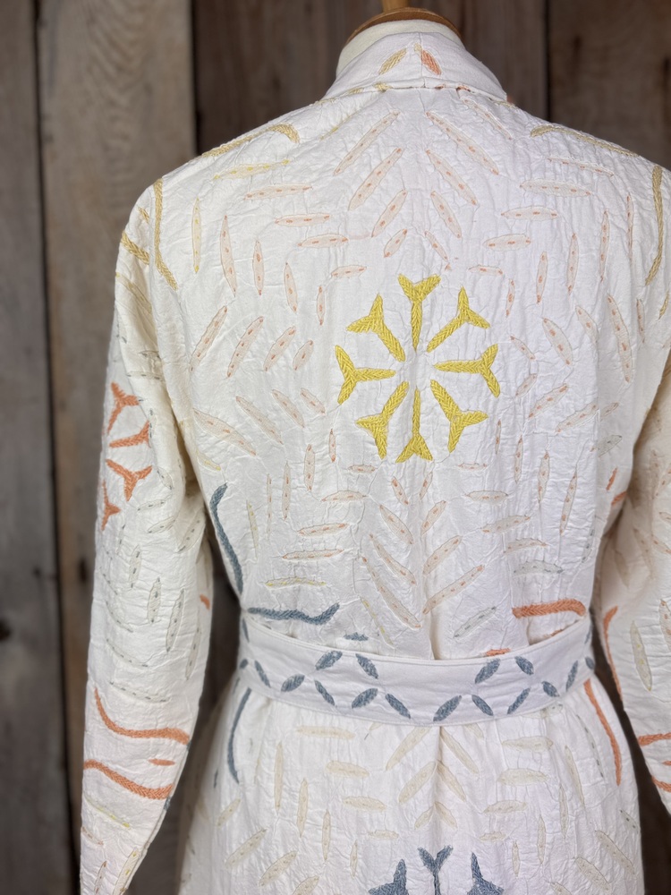 A luxury white dressing gown made using the traditional Indian technique of Cutwork. Additional hand embroidery in pastel shades.