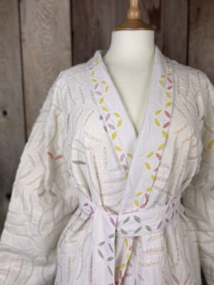 A luxury white dressing gown made using the traditional Indian technique of Cutwork. Additional hand embroidery in pastel shades.