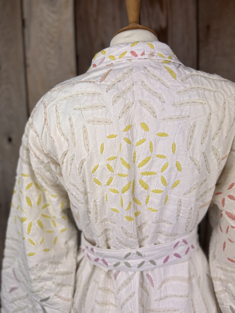 A luxury white dressing gown made using the traditional Indian technique of Cutwork. Additional hand embroidery in pastel shades.