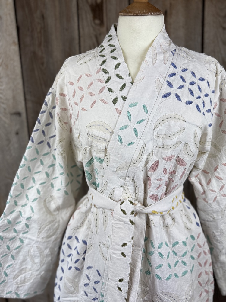 A luxury white dressing gown made using the traditional Indian technique of Cutwork. Additional hand embroidery in pastel shades.