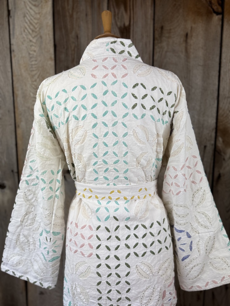A luxury white dressing gown made using the traditional Indian technique of Cutwork. Additional hand embroidery in pastel shades.