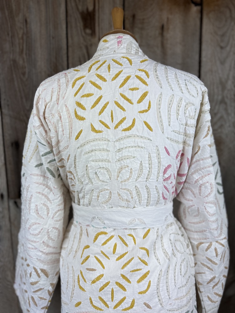 A luxury white dressing gown made using the traditional Indian technique of Cutwork. Additional hand embroidery in pastel shades.