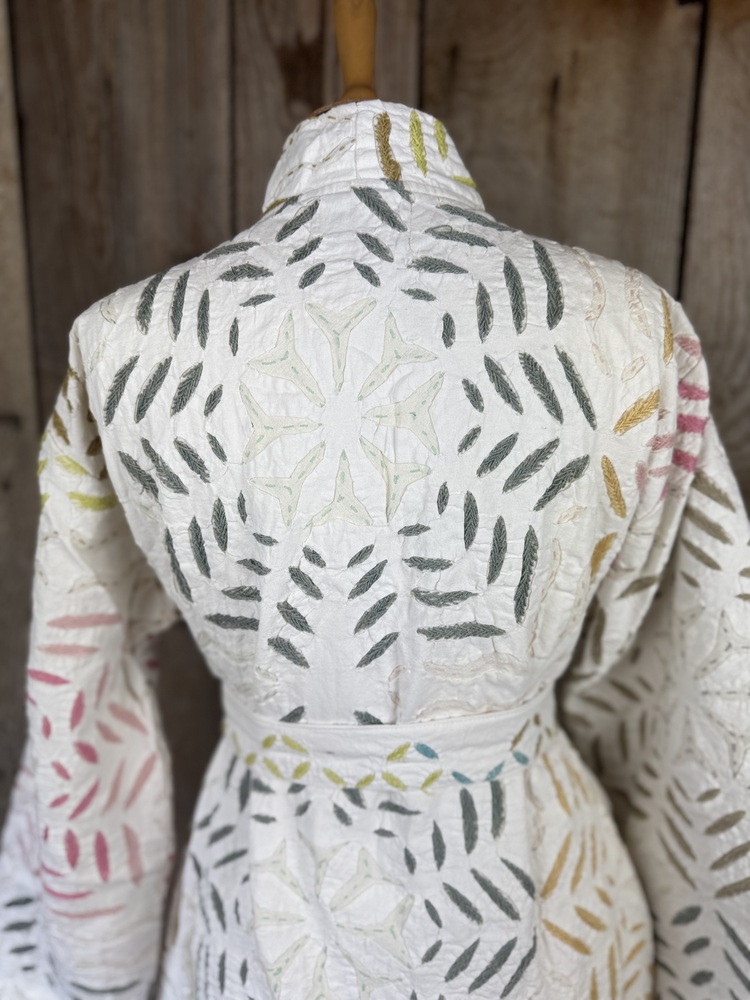 A luxury white dressing gown made using the traditional Indian technique of Cutwork. Additional hand embroidery in pastel shades.